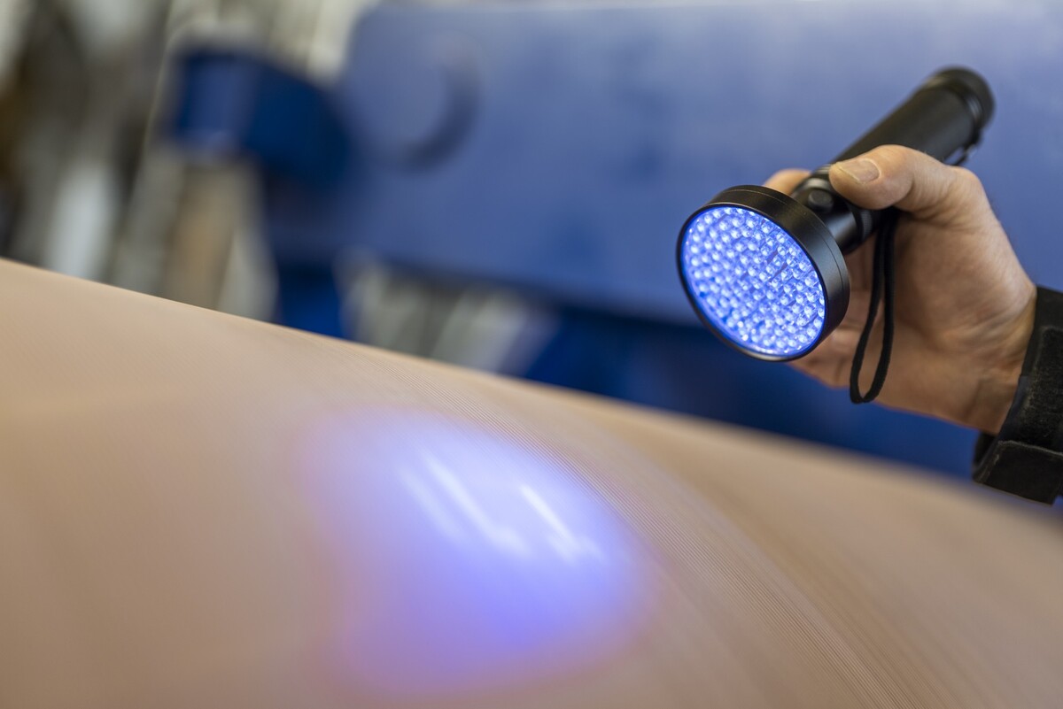 Due to its special properties and the use of UV light, Voith’s QView makes  invisible cracks in the press sleeve visible.